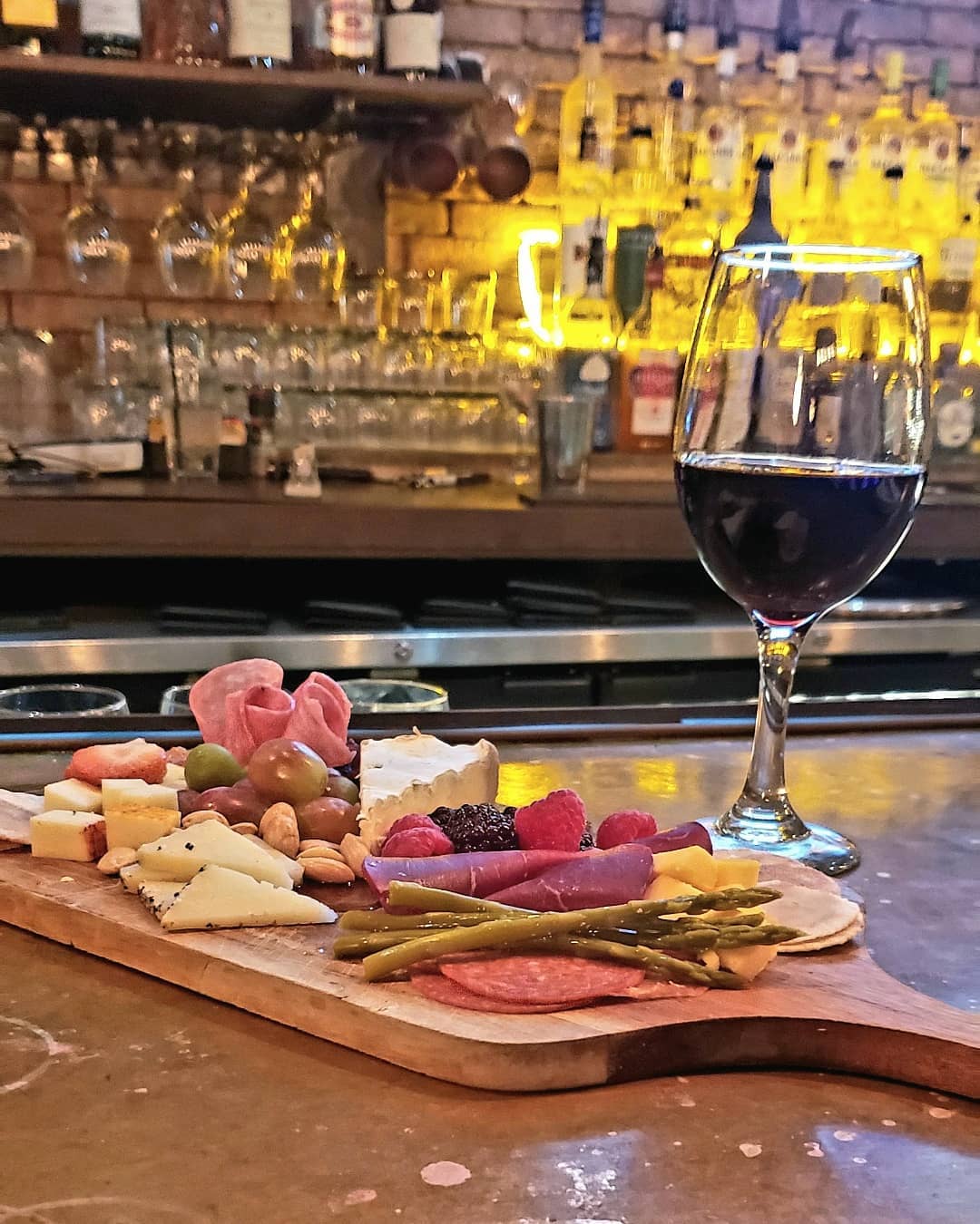 charcuterie board and glass of red wine