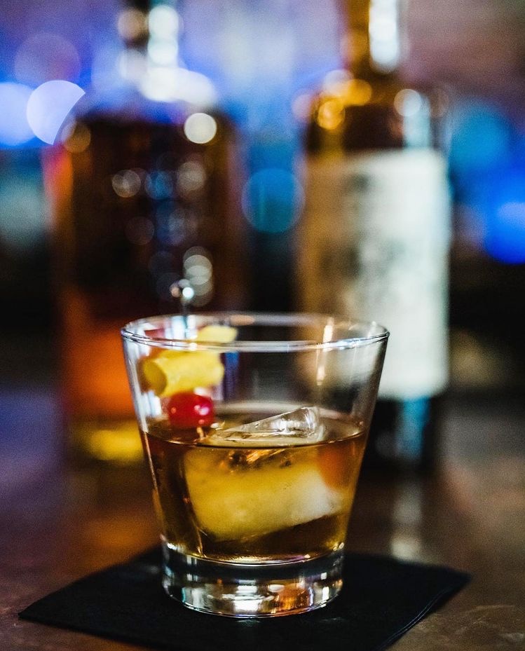 Cocktail glass of Bourbon on bar
